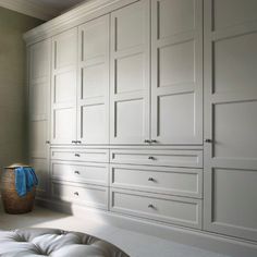 a bedroom with white cabinets and drawers in it