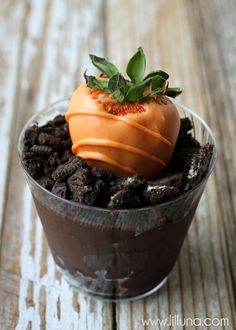 a chocolate dessert in a plastic cup on a wooden table