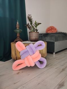 a pink and purple knot sitting on top of a wooden table