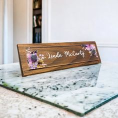 a wooden name plate sitting on top of a marble counter