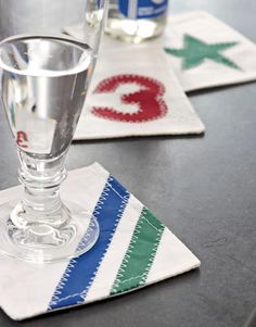 two glasses sitting on top of a table next to napkins with letters painted on them