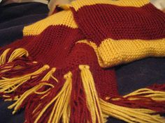 a red and yellow blanket laying on top of a bed