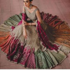 a woman in a red and gold bridal gown standing with her hands on her hips