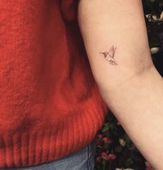 a small bird tattoo on the left arm