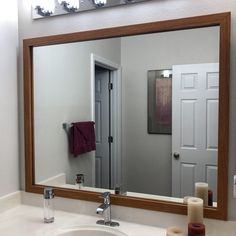 a bathroom sink with a mirror above it and candles on the counter next to it