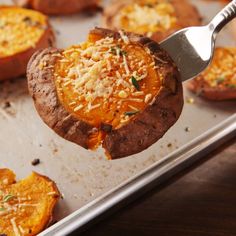 a spoon is lifting up some food from a baking pan