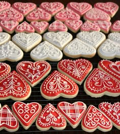 decorated heart shaped cookies on a cooling rack