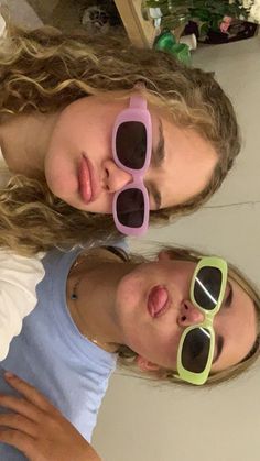 two girls with sunglasses on their faces posing for the camera