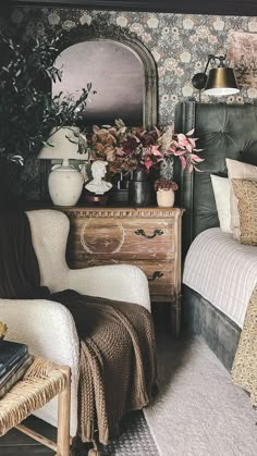 a bedroom with floral wallpaper and an old fashioned dresser next to the bed is decorated with potted plants