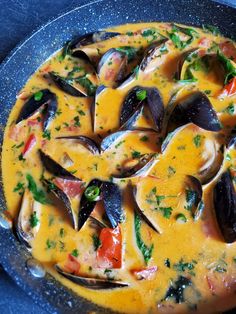 a pan filled with clams and sauce on top of a table