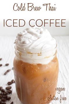 a mason jar filled with iced coffee and topped with whipped cream