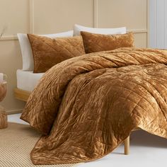 a bed with brown comforter and pillows in a room