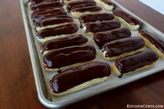 chocolate covered doughnuts sitting on top of a cookie sheet in a baking pan