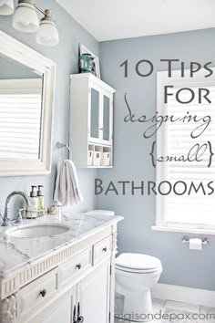 a white toilet sitting next to a sink in a bathroom under two large window shades