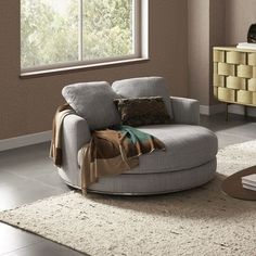 a living room with a round chair and rug on the floor next to a window