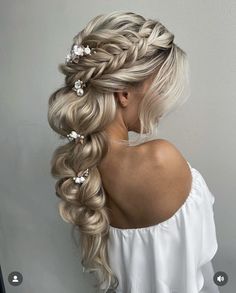 a woman with long blonde hair and flowers in her hair is shown from the back