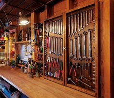 a room filled with lots of tools on top of a wooden shelf next to a window