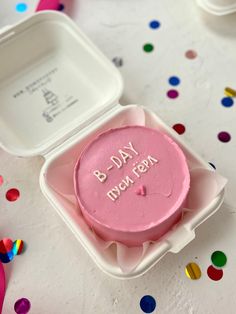 a pink birthday cake in a white container