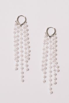 These pearl fringe hoop statement earrings are ready to party. Light and airy, full of movement, they will dance on your ears!Dimensions: Hangs 4" Materials: Simulated pearls, Alloy, 18k Gold Plating. Lever back closure.Ships in a branded jewelry pouch and box, perfect for gift giving! Pearl Charm Dangle Chandelier Earrings For Party, White Pearl Charm Chandelier Earrings For Party, Party Pearl Charm Hoop Earrings, Single Hoop Pearl Earring For Parties, White Chandelier Earrings With Pearl Chain For Party, Pearl Charm Dangle Hoop Earrings For Party, Dangle Hoop Earrings With Pearl Charm For Party, Pearl Chain Dangle Chandelier Earrings For Party, Party Pearl Chain Dangle Chandelier Earrings