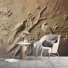 a chair sitting next to a table in front of a wall with birds on it