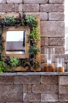 a brick wall with a mirror and plants on it