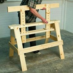 a man standing next to a chair made out of wooden planks and plywood