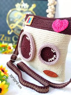 a crocheted camera bag sitting on top of a table