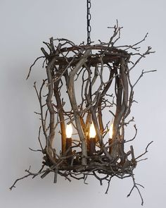 a chandelier made out of branches with three lights on each end and one light hanging from the ceiling