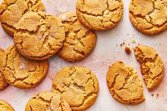 a bunch of cookies that are on top of a white table cloth and some have been cut in half