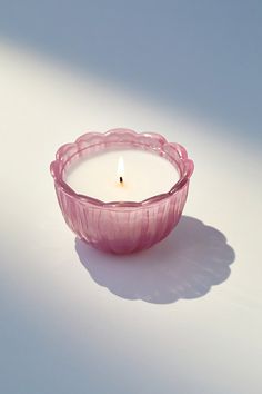 a pink candle sitting on top of a white table