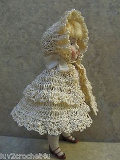 a doll is wearing a dress and hat