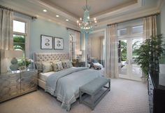 a bedroom with a large bed, chandelier and two windows in the room