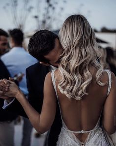 the back of a bride's dress as she kisses her groom