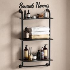 a bathroom shelf with towels, soaps and lotions on it that says sweet home