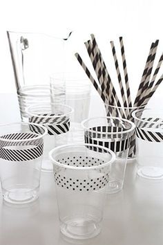 several cups with black and white striped straws in them on a table next to each other