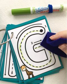 a hand is stamping out the letter s on top of several cards with markers