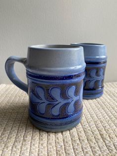 two blue mugs sitting on top of a table