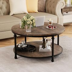 a living room with a couch, coffee table and laptop on top of the table