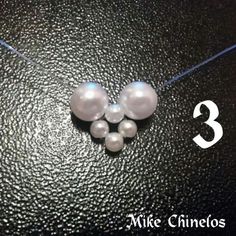 three white pearls on a black surface with the words mike chinelos written below them