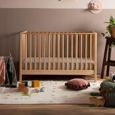 a baby's room with a crib and toys on the floor in front of it