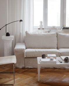 a living room with a white couch and coffee table in front of a large window