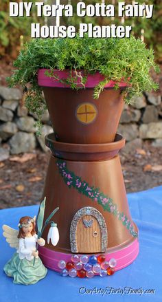 a potted plant sitting on top of a table next to a fairy figurine