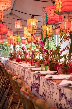 a long table is set up with flowers and lanterns