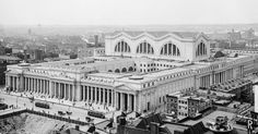 black and white photograph of an old building in the middle of a city with tall buildings