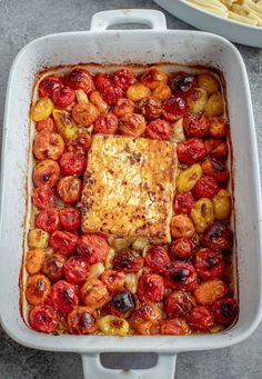 a casserole dish with tomatoes, potatoes and meat in it next to a bowl of macaroni and cheese