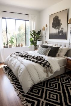 a large bed sitting in a bedroom on top of a hard wood floor next to a window