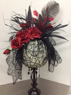 a vase filled with flowers and feathers on top of a table