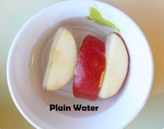 two pieces of apple in a white bowl with the word plain water on it next to an apple slice