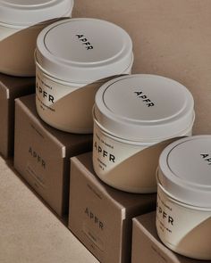 four empty containers sitting on top of cardboard boxes next to each other in front of a wall