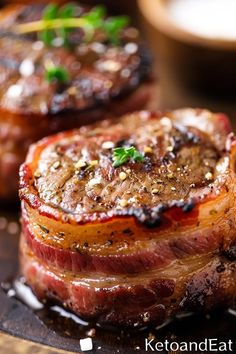 two steaks on a plate with herbs and seasoning